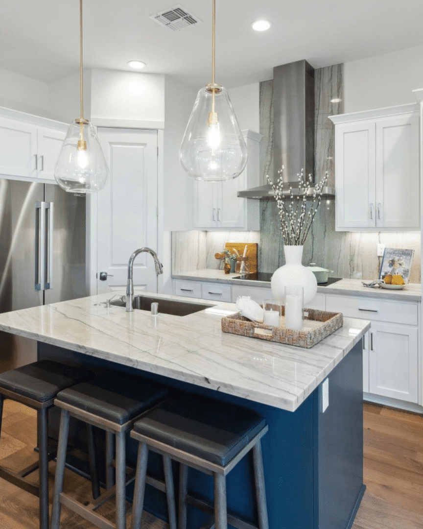 Modern kitchen with island and pendant lights.