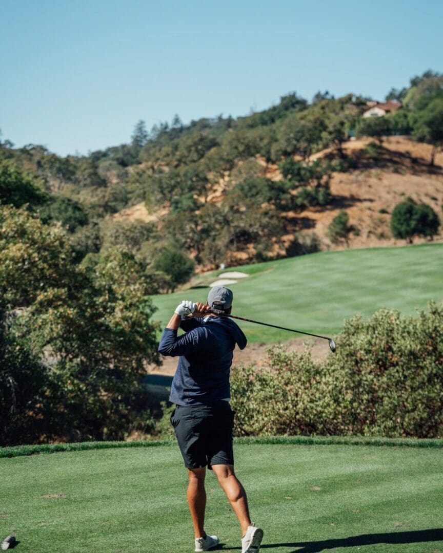 Golfer following through on lush green fairway